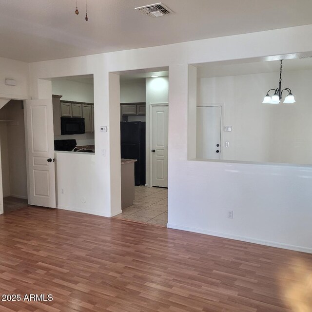 6908 S 8th Dr, Phoenix, AZ 85041 - unfurnished room featuring a notable chandelier, visible vents, baseboards, and light wood finished floors