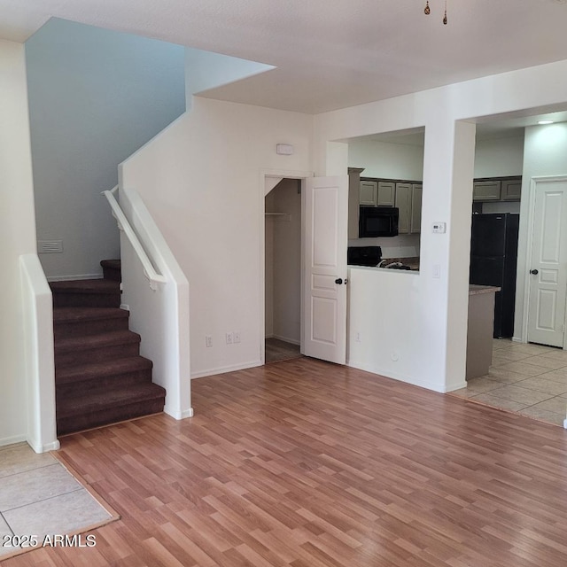 6908 S 8th Dr, Phoenix, AZ 85041 - unfurnished living room featuring baseboards, light wood-style flooring, and stairs