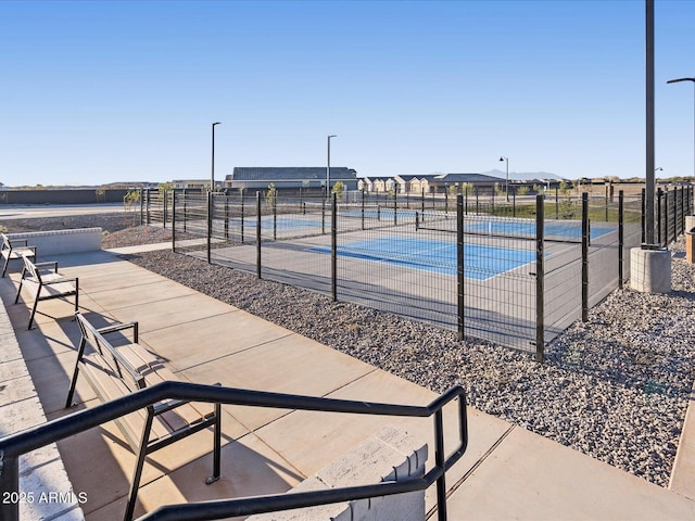surrounding community featuring a tennis court and fence