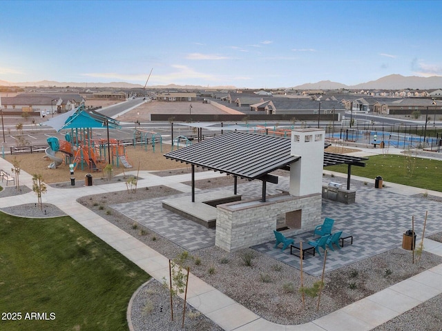 view of property's community featuring a yard, a mountain view, a patio, and playground community