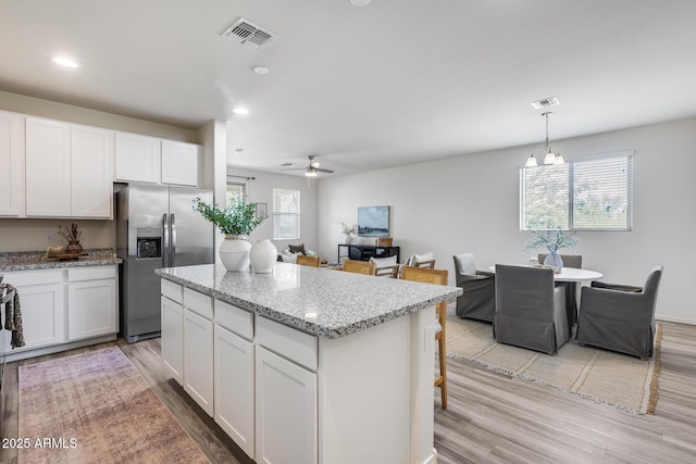 17728 W Paraiso Dr, Surprise, AZ 85387 - kitchen featuring stainless steel fridge with ice dispenser, a ceiling fan, a center island, light wood-type flooring, and recessed lighting