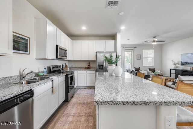 17728 W Paraiso Dr, Surprise, AZ 85387 - kitchen featuring stainless steel appliances, a sink, a center island, open floor plan, and wood finished floors