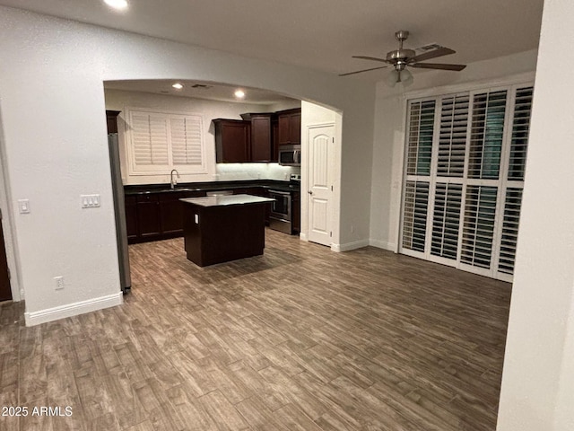 3480 E Sheffield Rd, Gilbert, AZ 85296 - kitchen with stainless steel appliances, a kitchen island, ceiling fan, arched walkways, and open floor plan