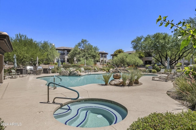 view of swimming pool featuring a community hot tub and a patio area