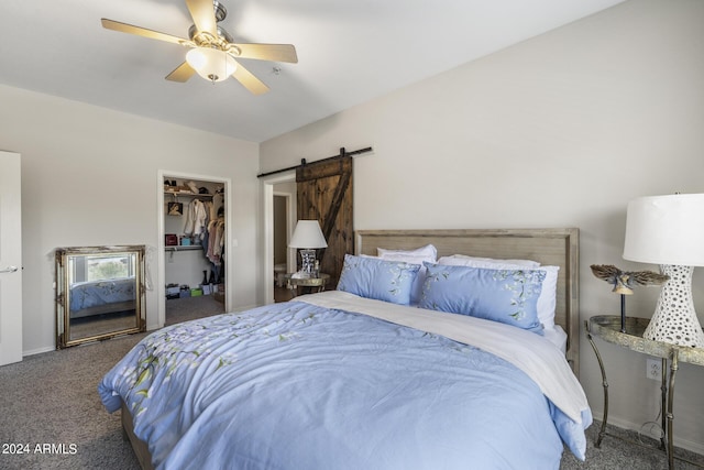 bedroom with a closet, a barn door, carpet, ceiling fan, and a walk in closet