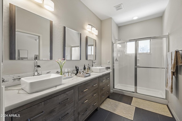 bathroom featuring tile patterned floors, a shower with shower door, and vanity