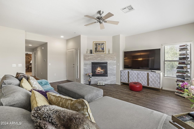 living room featuring dark hardwood / wood-style flooring, a tile fireplace, and ceiling fan