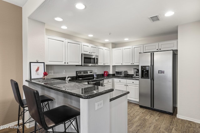 kitchen featuring stainless steel appliances, white cabinets, and kitchen peninsula