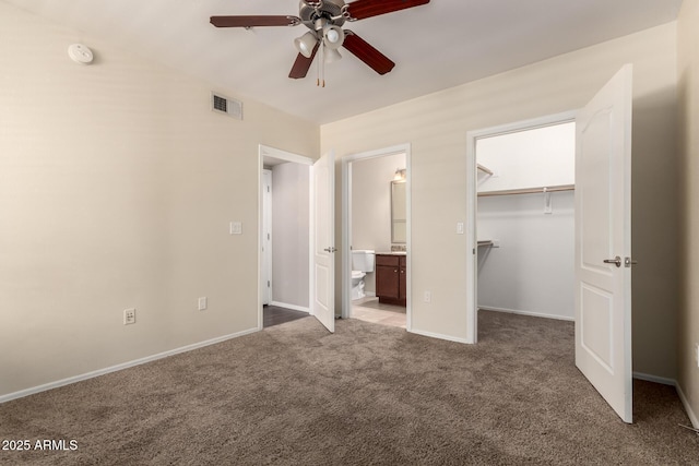 2134 E Broadway Rd Unit 1062, Tempe, AZ 85282 - unfurnished bedroom with carpet floors, a walk in closet, connected bathroom, a closet, and a ceiling fan