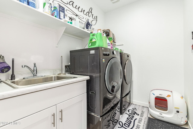 laundry area featuring cabinets, light wood-type flooring, sink, and washing machine and clothes dryer