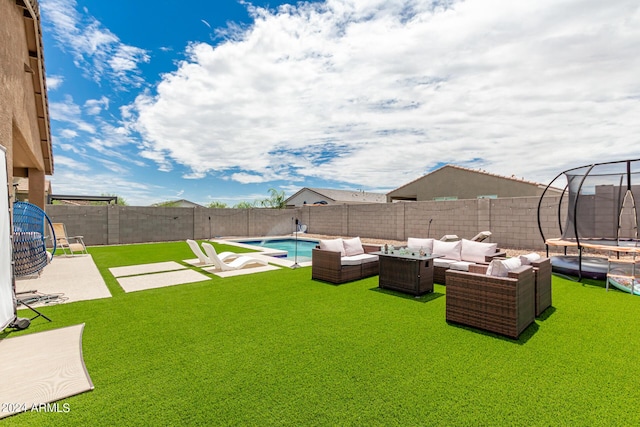 view of yard featuring outdoor lounge area, a trampoline, a patio area, and a fenced in pool