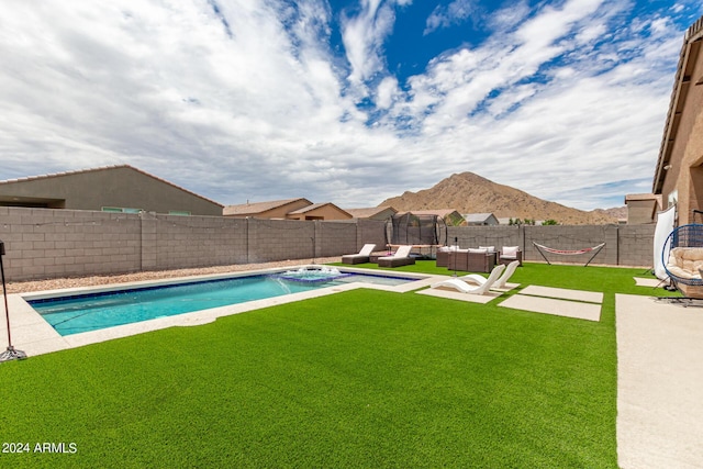 view of swimming pool with a lawn, a mountain view, and an outdoor hangout area