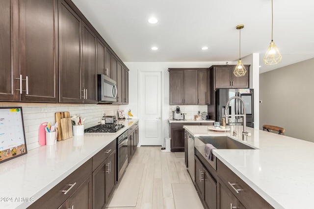 kitchen with light stone countertops, tasteful backsplash, decorative light fixtures, dark brown cabinets, and stainless steel appliances