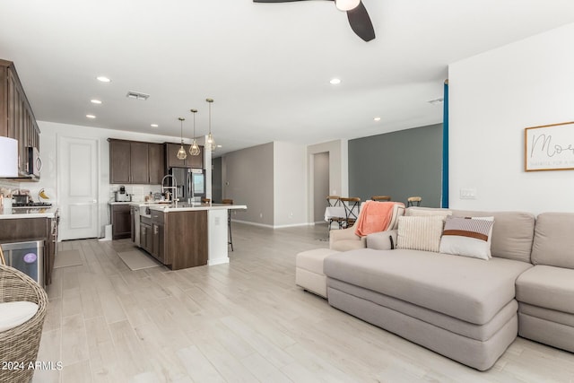 living room featuring ceiling fan and light wood-type flooring