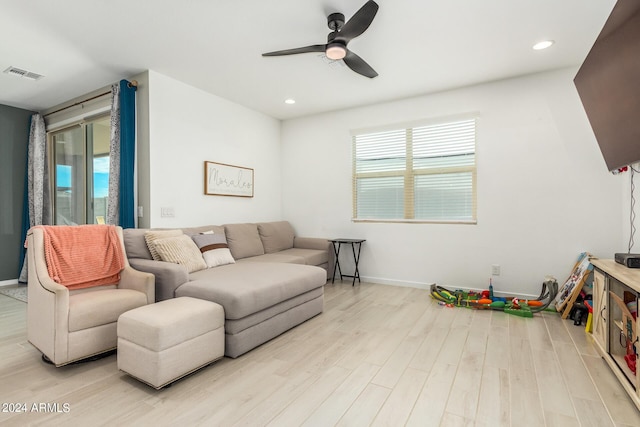 living room featuring ceiling fan, light hardwood / wood-style flooring, and a healthy amount of sunlight