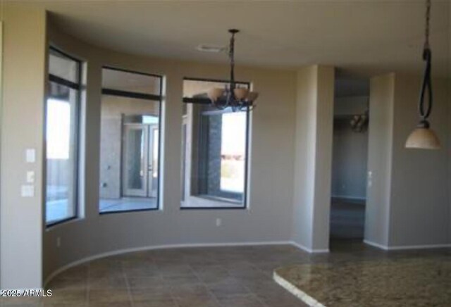 interior space with a notable chandelier and baseboards