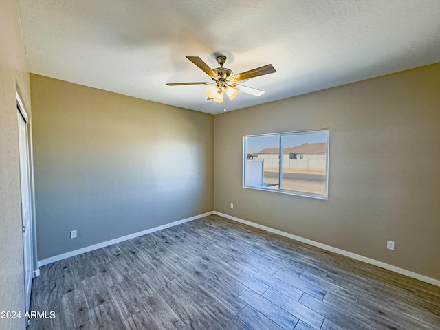 empty room featuring a textured ceiling, dark hardwood / wood-style flooring, and ceiling fan