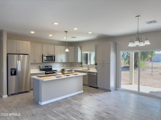 kitchen featuring gray cabinetry, stainless steel appliances, sink, an inviting chandelier, and hanging light fixtures