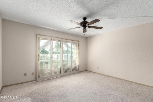 carpeted empty room featuring ceiling fan and a textured ceiling