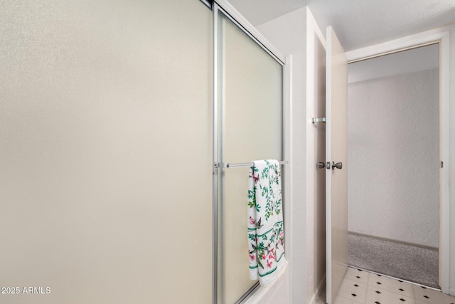 bathroom with a textured ceiling and walk in shower