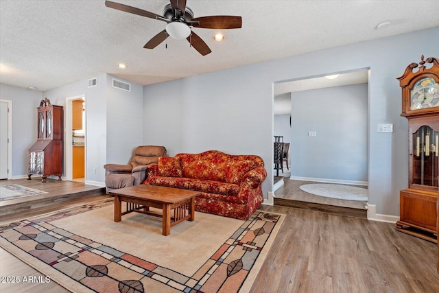 8545 E Heatherbrae Dr, Scottsdale, AZ 85251 - living room with wood finished floors, a ceiling fan, a textured ceiling, baseboards, and recessed lighting