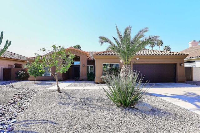 view of front of house with a tiled roof, stucco siding, an attached garage, and driveway