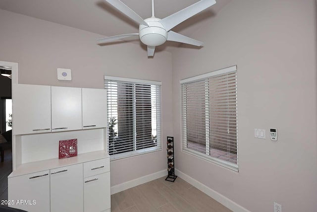 interior space featuring baseboards and ceiling fan