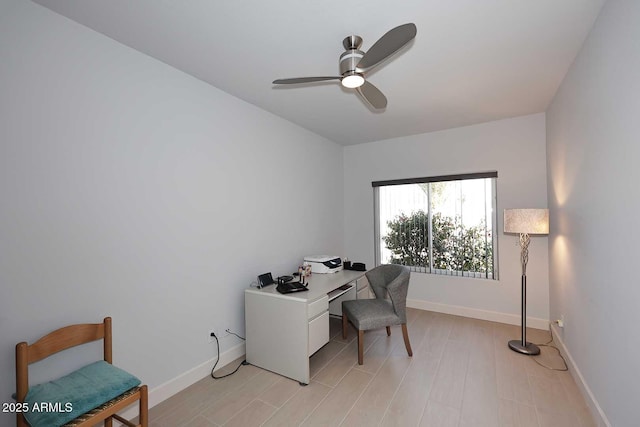 home office featuring a ceiling fan, light wood-style floors, and baseboards