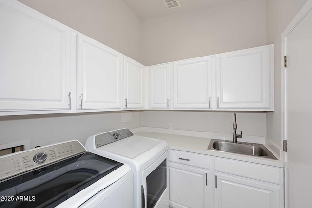 washroom featuring visible vents, cabinet space, independent washer and dryer, and a sink