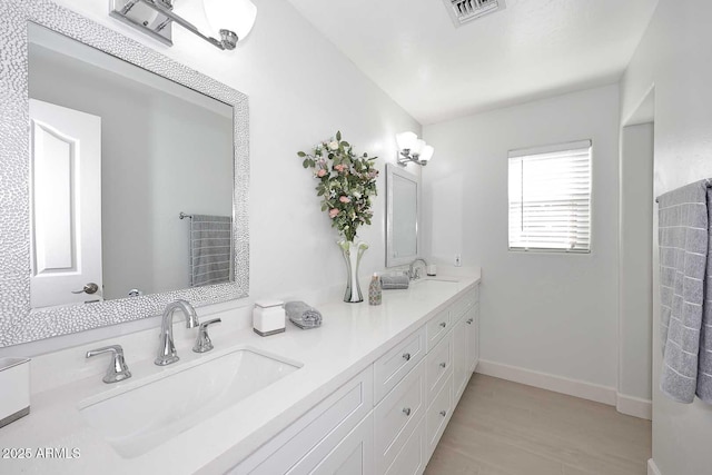 full bathroom with double vanity, visible vents, baseboards, and a sink