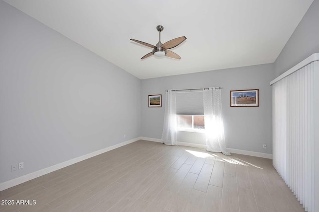 unfurnished bedroom featuring baseboards, light wood-style floors, a ceiling fan, and vaulted ceiling