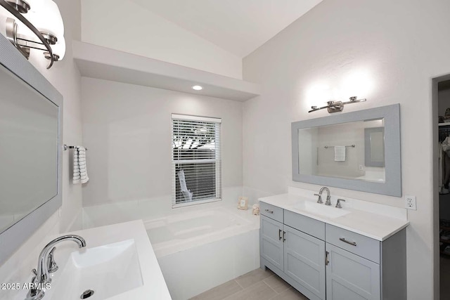 bathroom featuring a sink, lofted ceiling, and a garden tub