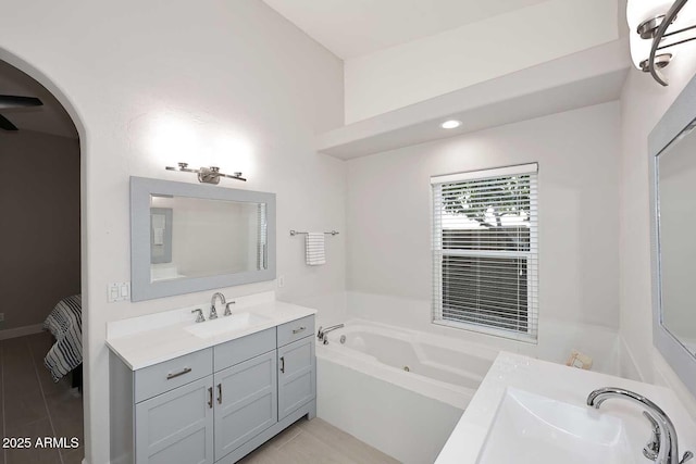 full bathroom with vanity, a bath, and wood finished floors