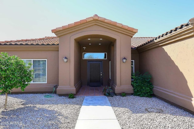 property entrance featuring stucco siding and a tile roof