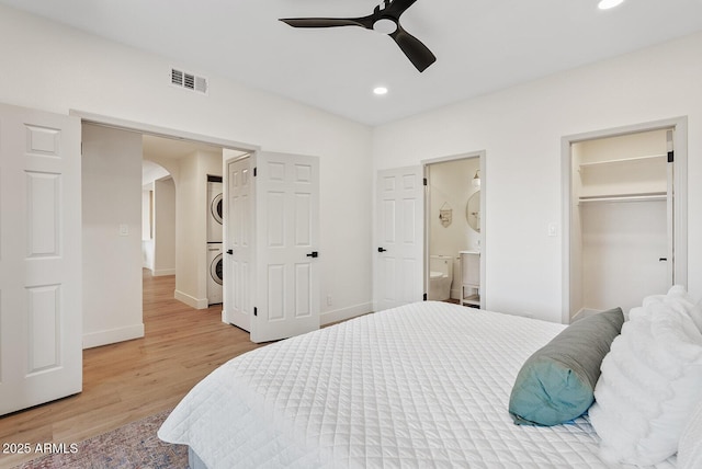 9708 E Via Linda Rd Unit 1350, Scottsdale, AZ 85258 - bedroom featuring stacked washer / drying machine, light wood-style flooring, arched walkways, recessed lighting, and baseboards