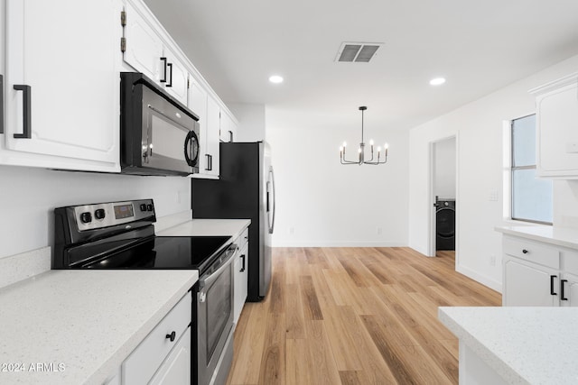 kitchen with hanging light fixtures, washer / dryer, white cabinetry, electric range, and light hardwood / wood-style floors