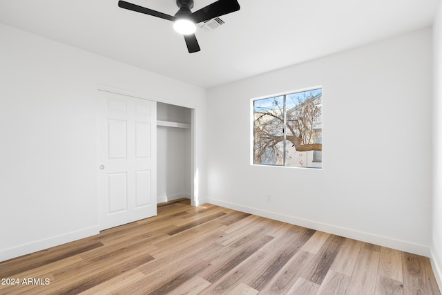 unfurnished bedroom with ceiling fan, light hardwood / wood-style floors, and a closet