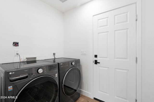 washroom featuring wood-type flooring and washer and dryer