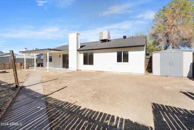 back of house with cooling unit, a patio, and a storage shed