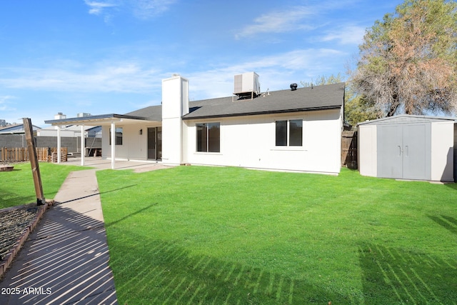 back of house with a storage unit, a patio, central AC unit, and a yard