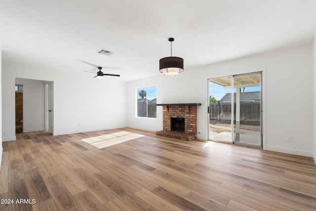 unfurnished living room featuring ceiling fan, light hardwood / wood-style floors, and a fireplace