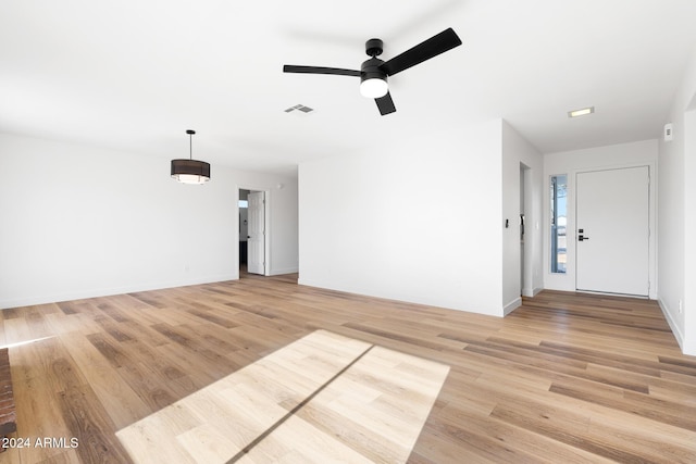 unfurnished living room featuring ceiling fan and light hardwood / wood-style flooring