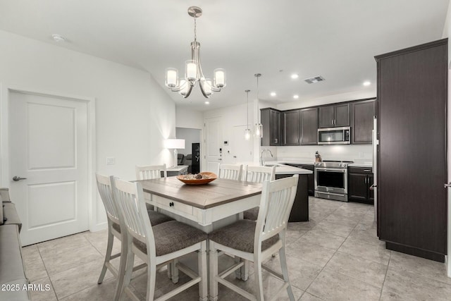 tiled dining area featuring sink and an inviting chandelier