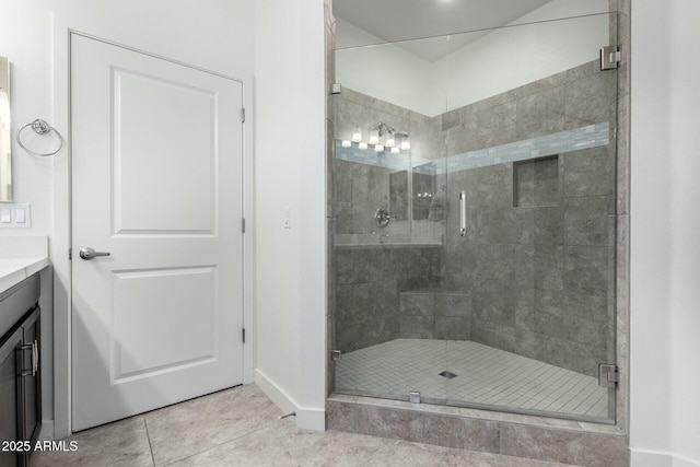 bathroom with tile patterned floors, walk in shower, and vanity