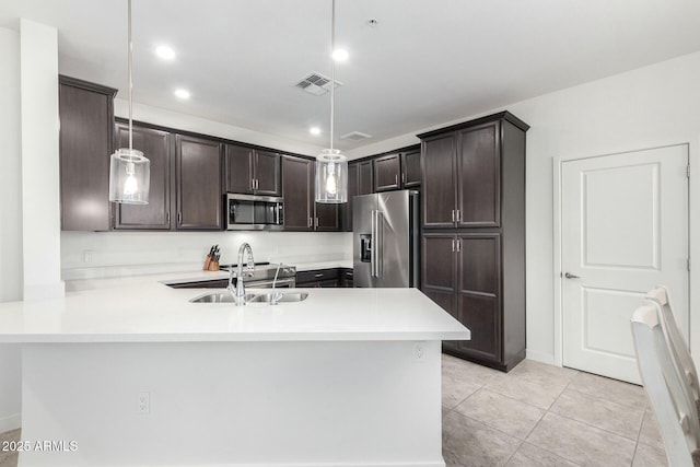 kitchen with kitchen peninsula, sink, hanging light fixtures, and appliances with stainless steel finishes