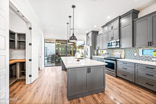 306 W Culver St, Phoenix, AZ 85003 - kitchen featuring appliances with stainless steel finishes, gray cabinetry, light countertops, tasteful backsplash, and light wood-style floors