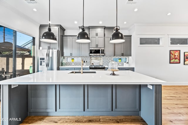 306 W Culver St, Phoenix, AZ 85003 - kitchen with appliances with stainless steel finishes, a sink, a spacious island, decorative backsplash, and light countertops