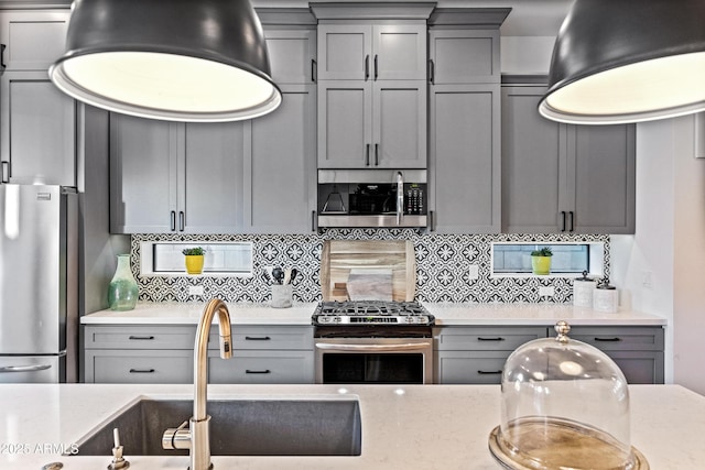306 W Culver St, Phoenix, AZ 85003 - kitchen featuring gray cabinetry, appliances with stainless steel finishes, a sink, and decorative backsplash
