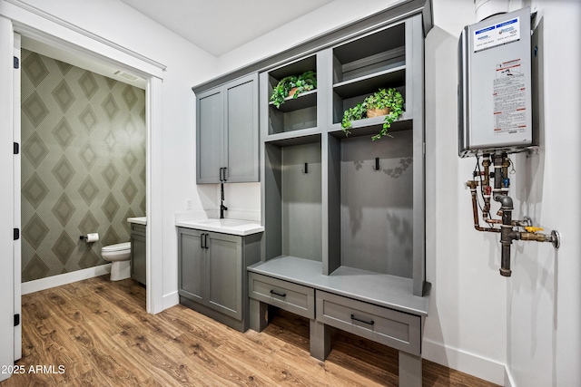 306 W Culver St, Phoenix, AZ 85003 - mudroom with wallpapered walls, tankless water heater, baseboards, and wood finished floors