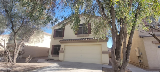 view of front of house featuring an attached garage, fence, concrete driveway, a tiled roof, and stucco siding